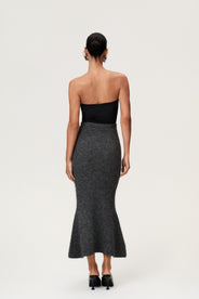 Woman wearing a Cessole midi skirt in dark grey. The skirt features a structured knit, midi length, zipper on the side, curved cutline in the waist, and softly flared bottom. thumbnail image