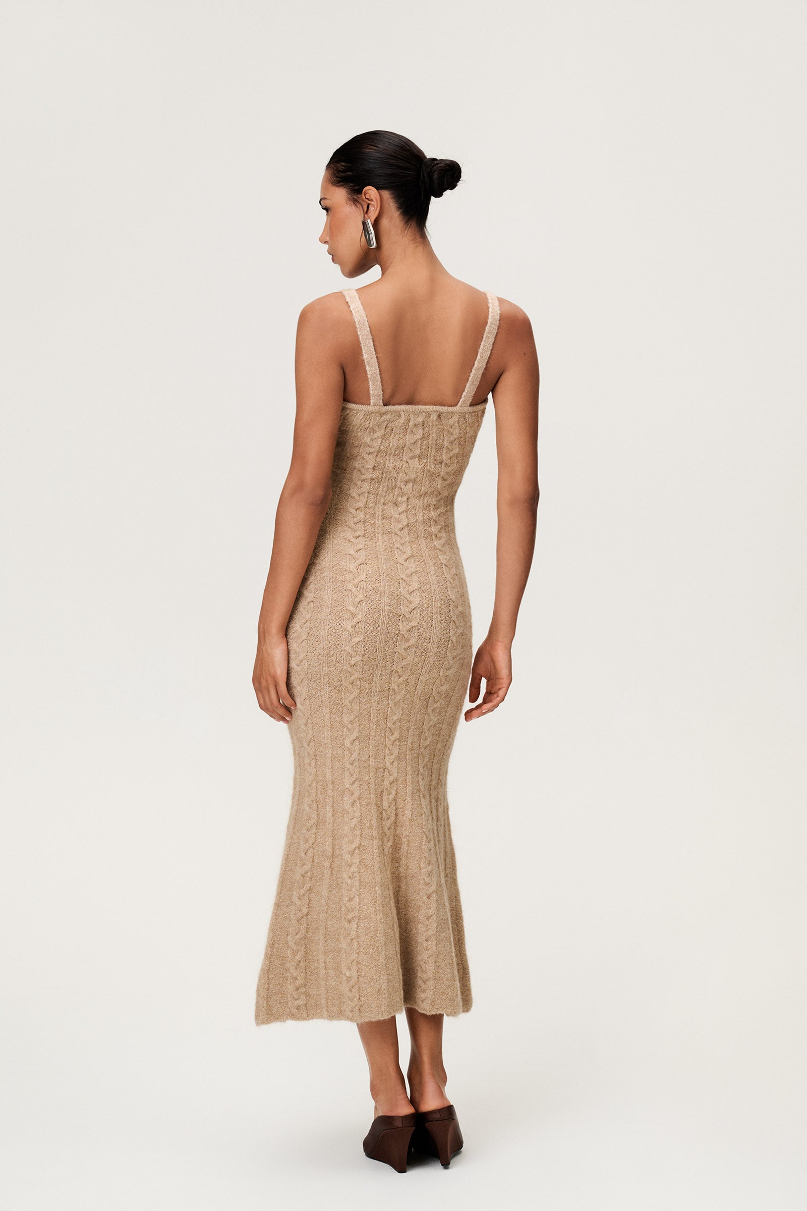 Woman wearing the Merano maxi dress in beige melange, a sleek, figure-flattering style with delicate singlet straps, a deep V-neckline, and an hourglass fit. image