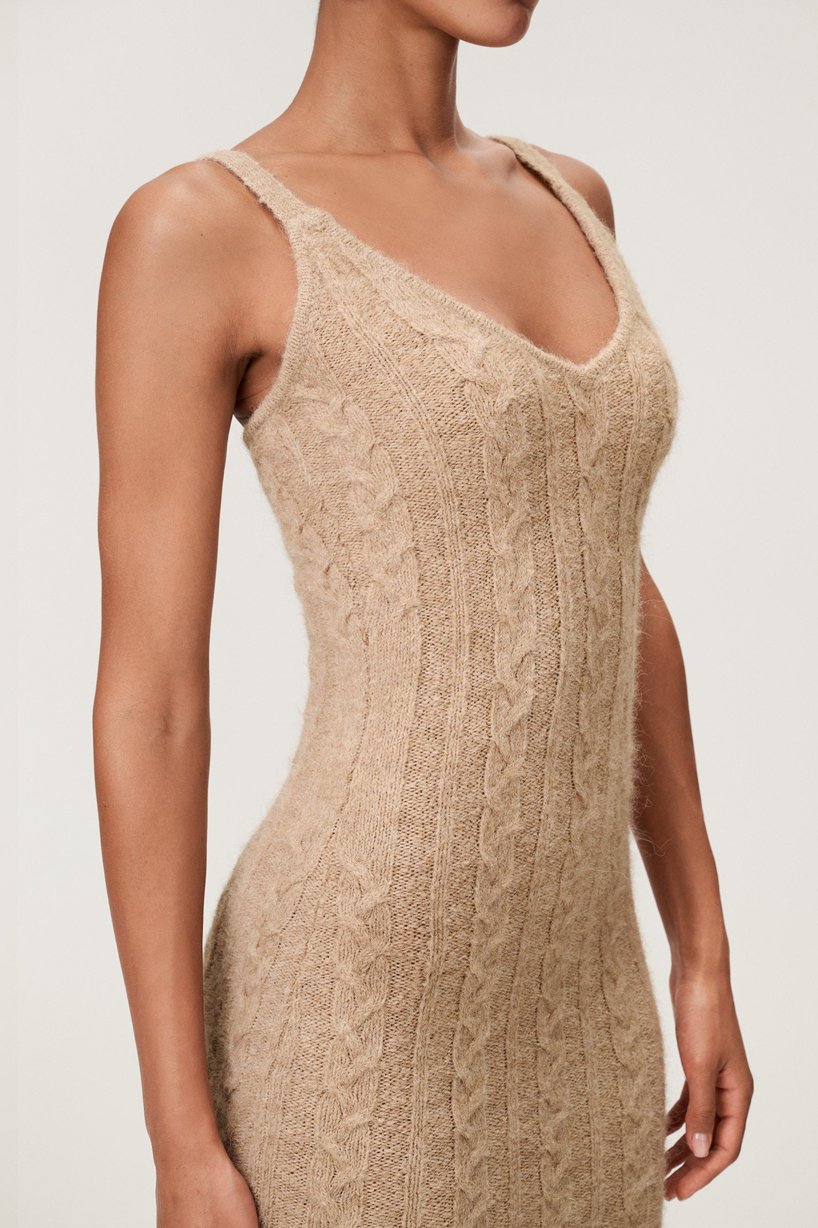 Woman wearing the Merano maxi dress in beige melange, a sleek, figure-flattering style with delicate singlet straps, a deep V-neckline, and an hourglass fit. image