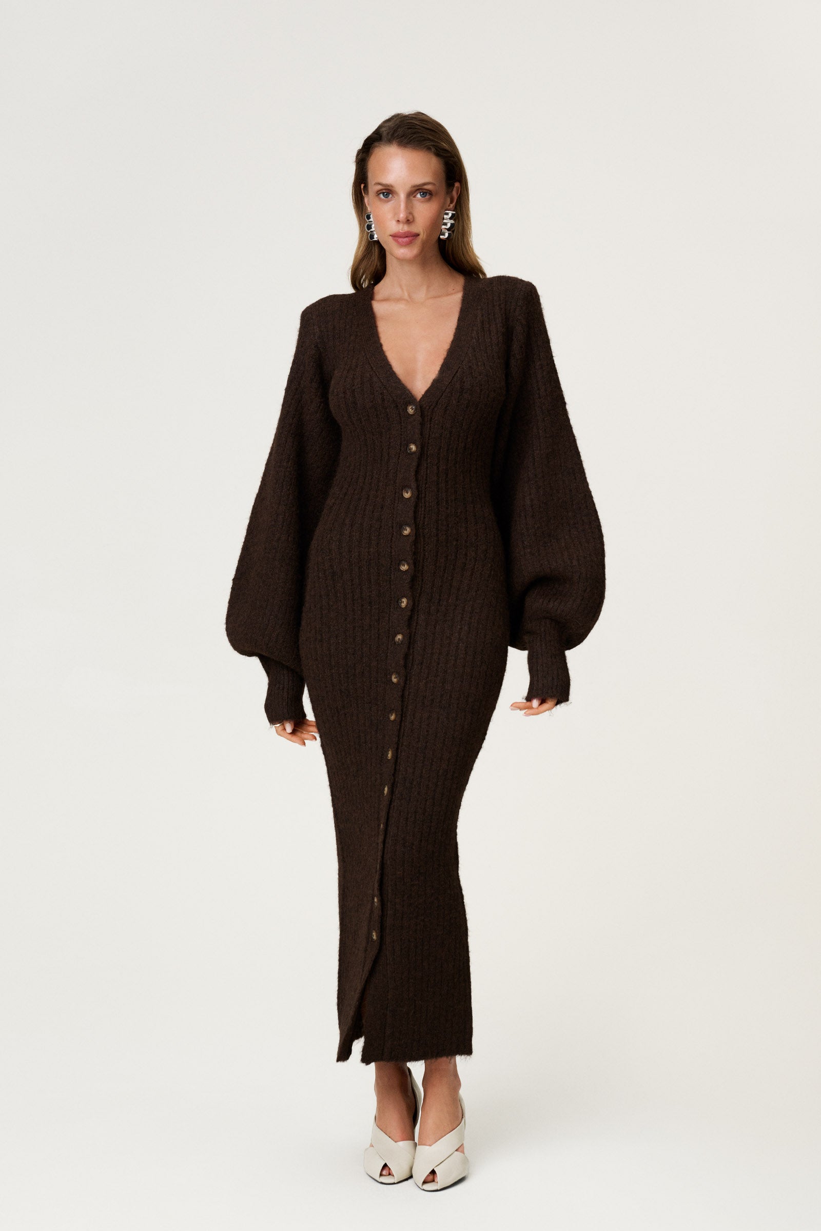 Woman wearing the Montana maxi dress in brown melange featuring an hourglass knit with a button-up front, V-neck collar, and balloon sleeves with cuff details. image