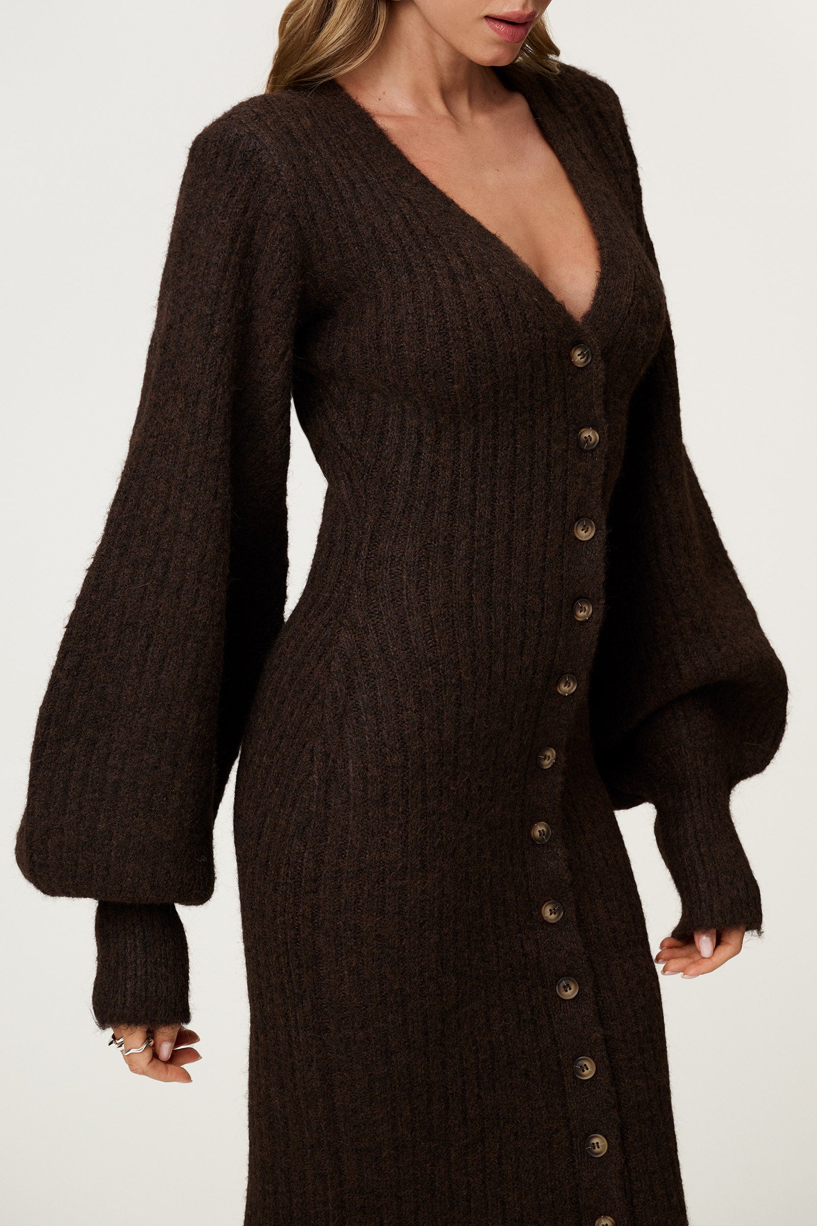 Woman wearing the Montana maxi dress in brown melange featuring an hourglass knit with a button-up front, V-neck collar, and balloon sleeves with cuff details. image