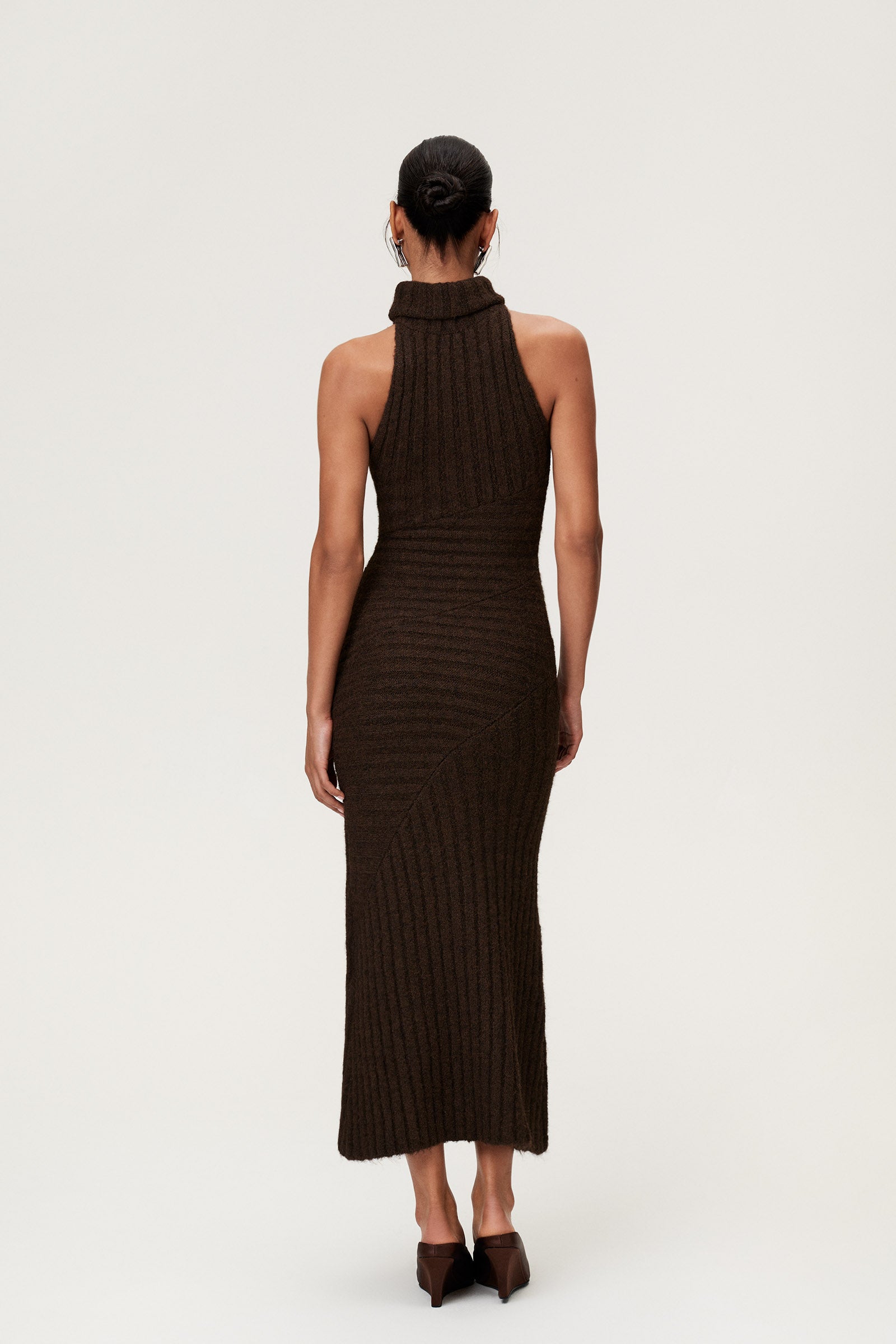Woman wearing the Montreux maxi dress in brown melange with a voluminous halterneck, light wool-blend knit, and asymmetric panel details that flatter the figure. image