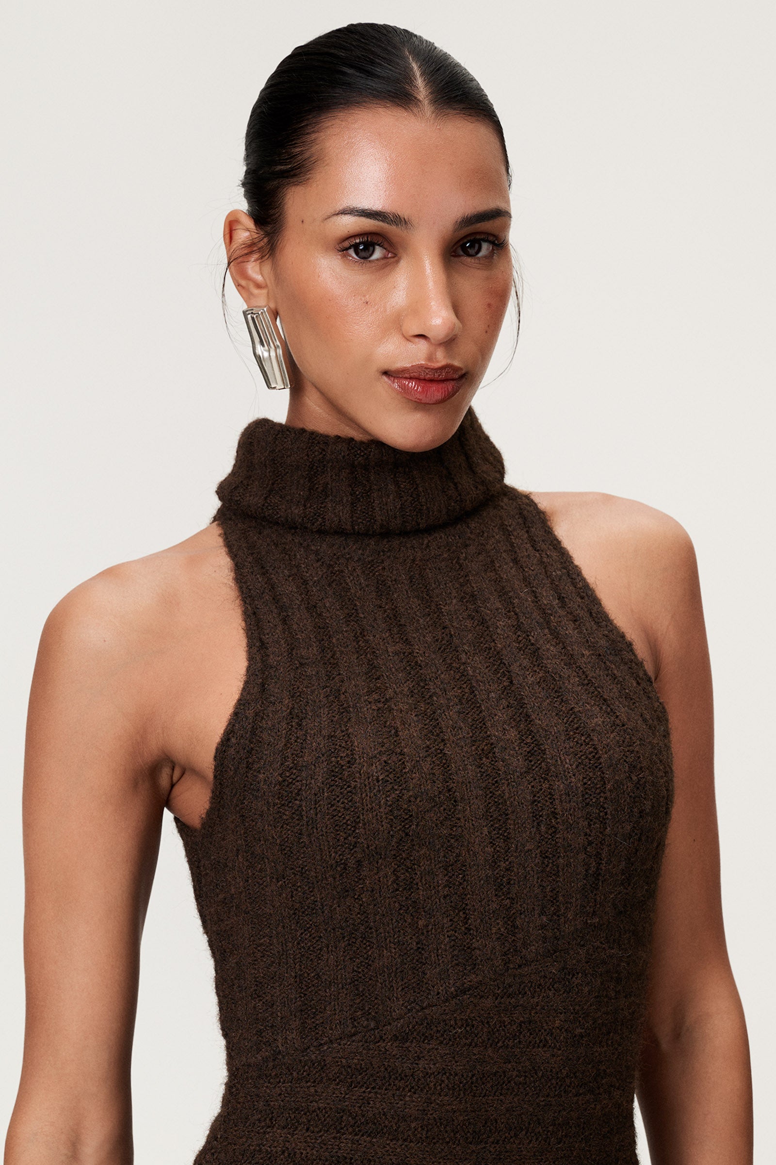 Woman wearing the Montreux maxi dress in brown melange with a voluminous halterneck, light wool-blend knit, and asymmetric panel details that flatter the figure. image