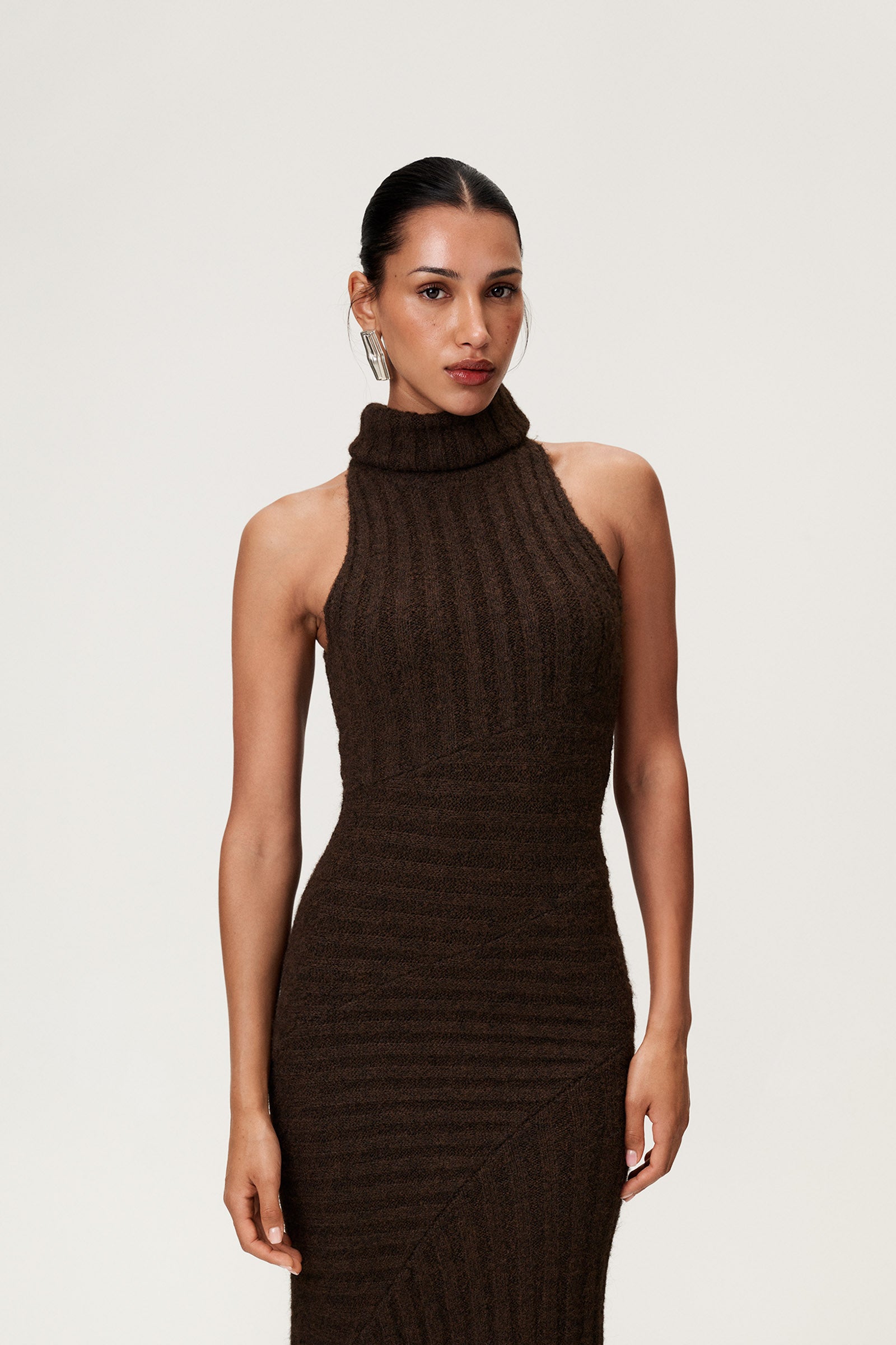Woman wearing the Montreux maxi dress in brown melange with a voluminous halterneck, light wool-blend knit, and asymmetric panel details that flatter the figure. image